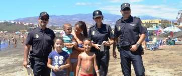 Los tres agentes uniformados que repartieron pulseras de seguridad entre los menores de Melenara (Foto TA)