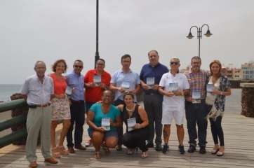 Miembros de la Corporación y del Patronato de Fiestas posan en el paseo con el programa en sus manos (Foto TA)