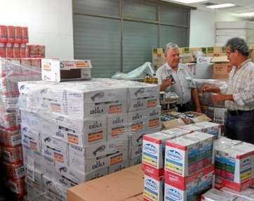 Guillermo Casañas y Germán Ramos con una parte de los alimentos que se guardan en Jinámar (Foto C7)