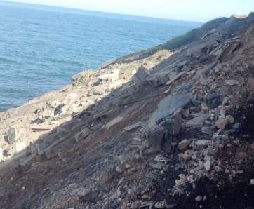 Imagen de los bloques, piedras y materiales de construcción que descansan sobre la ladera sur de Playa del Hombre (Foto TA)