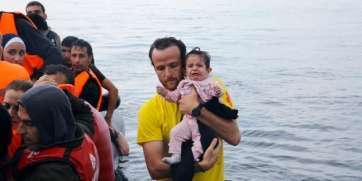 Un socorrista de ProActiva con un bebé en los brazos (Foto TA)