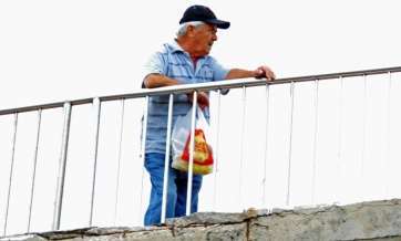 Vecino apoyado en la barrandilla en mal estado del paso (Foto TA)