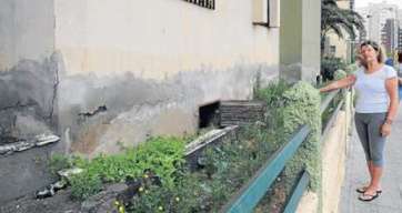 Rosario Guerle muestra la parte baja del edificio y el lugar donde se estanca el agua cuando se desborda (Foto G. Montesdeoca-C7)