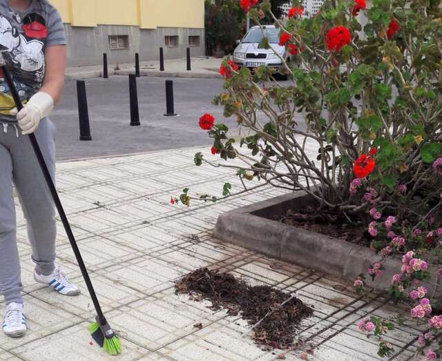 Una vecina barre la acera (Foto TA)