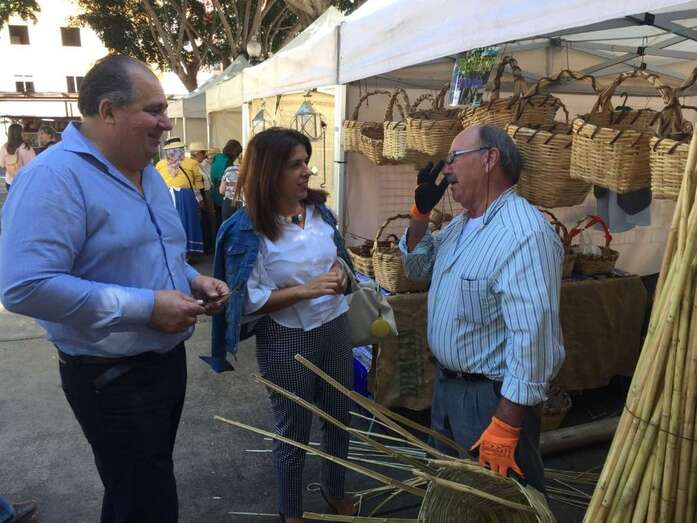 La alcaldesa y el concejal charlan con un fabricante de cestos de caña (Foto TA)