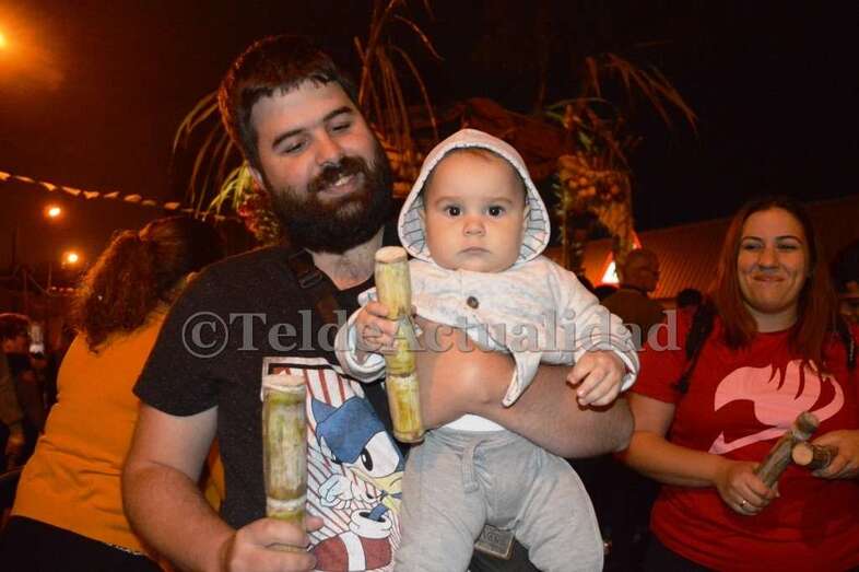 Un bebe porta en su mano un trozo de caña dulce, esta noche en Jinámar (Foto TA)