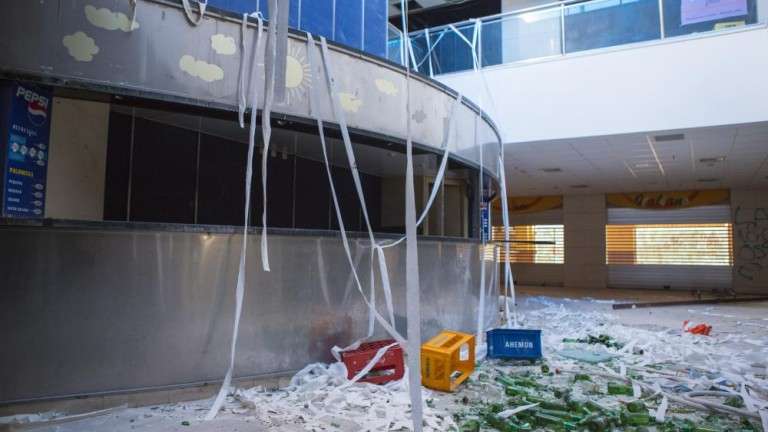 Vista parcial del hall principal del edificio, repleto de basura y botellas vacías de cerveza. Está justo delante de la taquilla de los cines (Foto Borja Suárez-C7)
