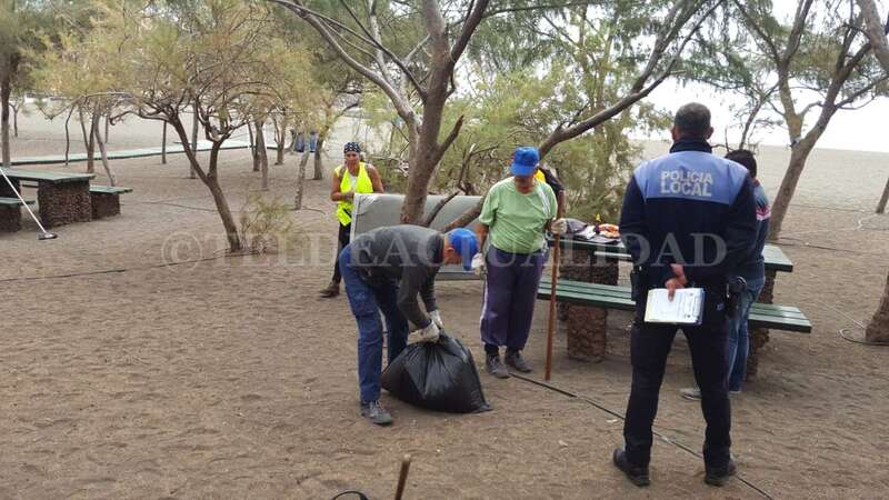 Los operarios municipales, recogiendo los efectos personales de la mujer (Foto TA)