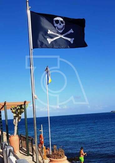 Bandera pirata izada en el mástil de la plaza pública de Ojos de Garza (Foto TA)