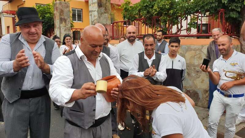 Salvador Santana, presidente de la comisión vecinal organizadora de las fiestas, bautiza a una vecina durante la diana floreada previa a la Traída de este año (Foto TA)