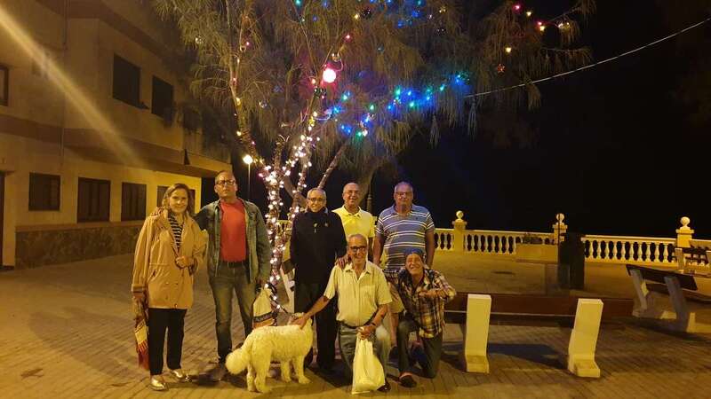 Los vecinos colocando esta mañana los adornos navideños en la Plaza de los Pinos (Foto TA)