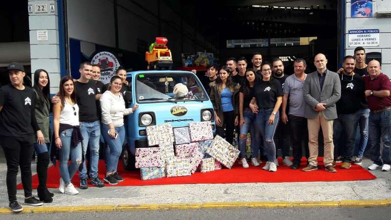 Empleados y amigos de Car Home Services, este domingo delante del taller con cajas de juguetes (Foto TA)