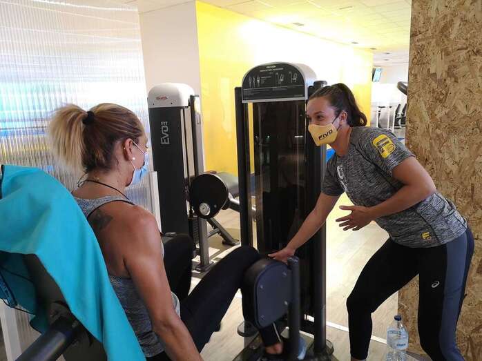 Una usuaria del Gimnasio Fivo 24 atiende las indicaciones de una monitora/TA.