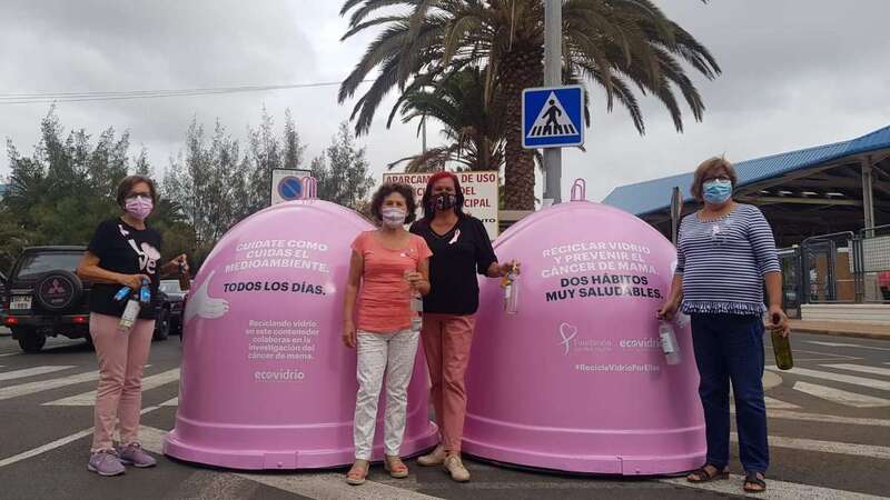 Miembros del colectivo junto a los contenedores rosas/TA.