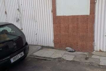 Coche aparcado en el vado de un almacén en una calle del casco de Jinámar/TA.