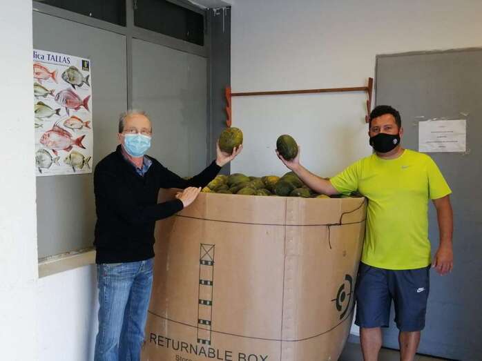 Miembros del colectivo muestran los melones donados/TA.
