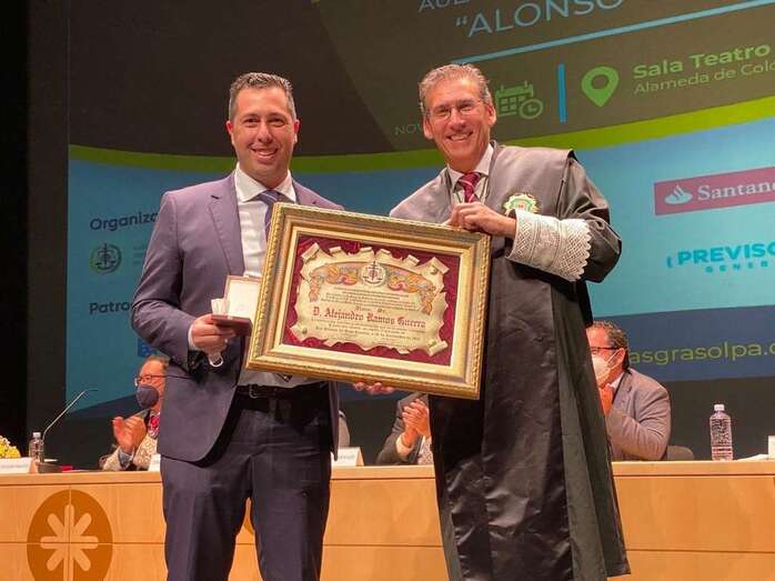 Alejandro Ramos (i), en el momento de recibir la Medalla de Oro y el Diploma de Colegiado de Honor de manos de Fermín Ojeda, presidente de Grasolpa/TA.