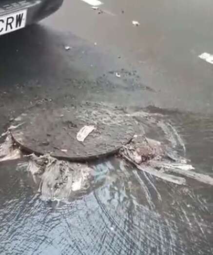 Las aguas fecales saliendo de la tapa de la red de saneamiento/TA.