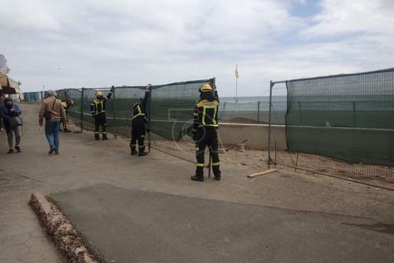 Los bomberos recolocan la valla caída de las obras del paseo de Melenara/TA.