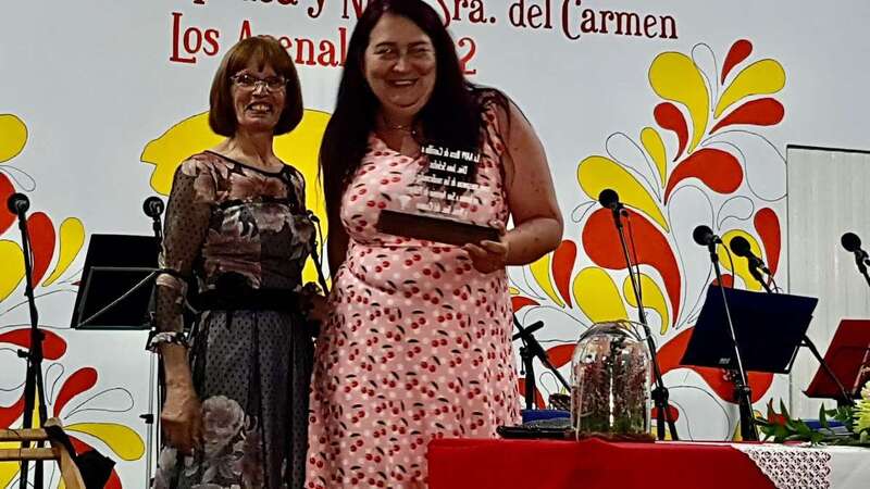 La pregonera muestra el detalle recibido de la comisión de fiestas de Los Arenales/TA.