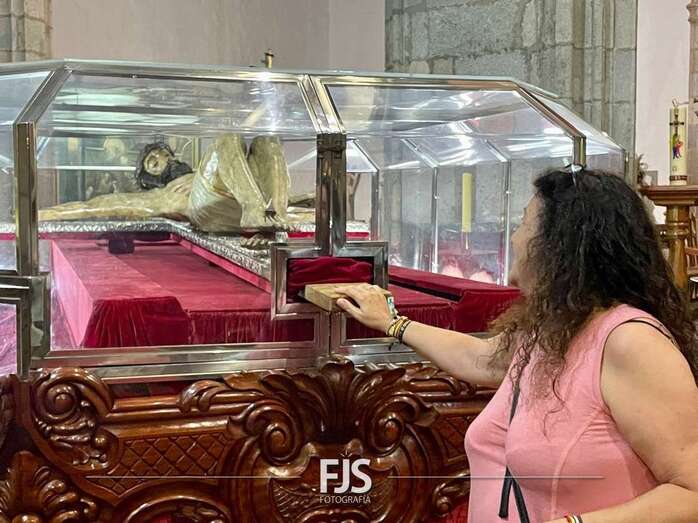 Una feligresa toca el madero de la cruz de la venerada imagen, en el interior del Cristo Movil/Francisco Javier Santana.