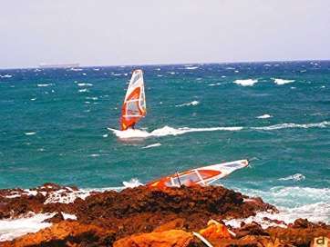 La surfera con su tabla cerca de los riscos (Foto José Verona)