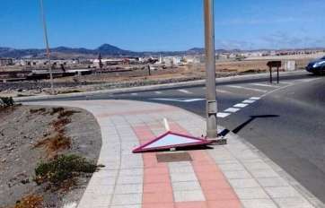 Señal de tráfico tirada al suelo en el vial costero en una imagen captada este domingo (Foto TA)