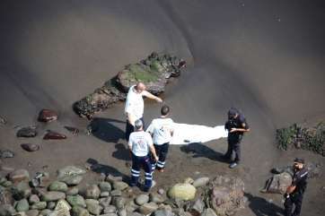 Policías y personal sanitario supervisan el cuerpo,el pasado jueves en la playa de San Borondón (Foto TA)