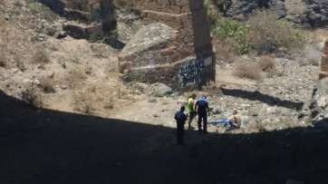 Agentes de la Policía Local y vecinos asisten al herido en el fondo del Barranco de los Ríos (Foto TR)