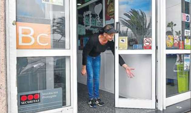 Una de las trabajadoras señala el hueco que quedó en la puerta por la rotura del cristal.(Foto Arcadio Suárez-C7)