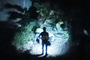 Agentes policiales junto al puente alumbran con linternas el lugar donde está el cadáver (Foto TA)