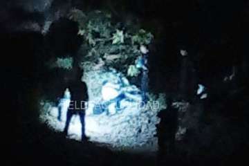 Agentes policiales junto al puente alumbran con linternas el lugar donde está el cadáver (Foto TA)
