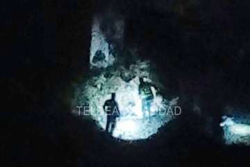 Agentes policiales junto al puente alumbran con linternas el lugar donde está el cadáver (Foto TA)