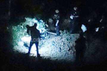 Agentes policiales junto al puente alumbran con linternas el lugar donde está el cadáver (Foto TA)