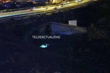 Agentes policiales junto al puente alumbran con linternas el lugar donde está el cadáver (Foto TA)