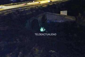 Agentes policiales junto al puente alumbran con linternas el lugar donde está el cadáver (Foto TA)