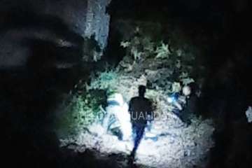 Agentes policiales junto al puente alumbran con linternas el lugar donde está el cadáver (Foto TA)