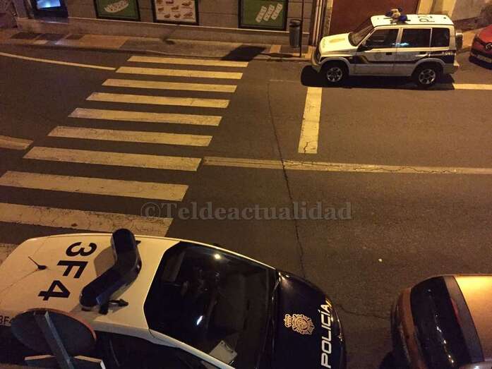 Coches policiales aparcados en La Baranquera, el pasado domingo por la noche, cerca del domicilio donde se halló el cadáver (Foto TA)