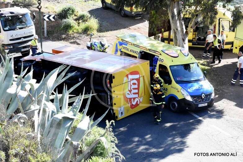 Bomberos y una ambulancia junto al camión volcado que conducía la joven conductora (Foto TA)