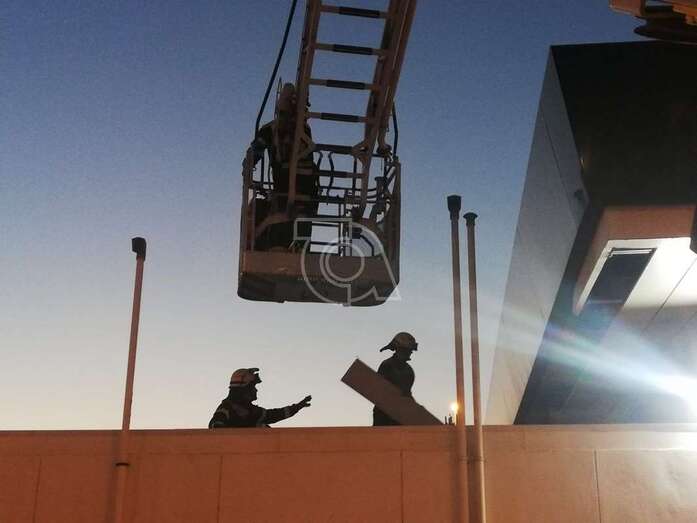 Los bomberos retirando la plancha desprendida del techo (Foto TA)