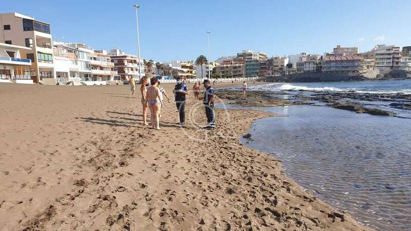 Momento en que las dos bañistas son sancionadas por la Policía Local (Foto TA)