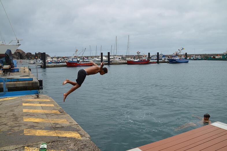 Jóvenes tirándose del muelle de Taliarte al agua/TA.